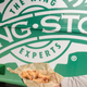 hand holding wings in front of wingstop truck